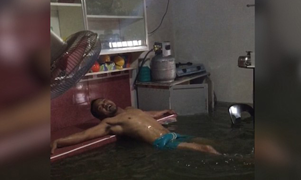 菲律宾男子洪水过后将漫水客厅当私人泳池