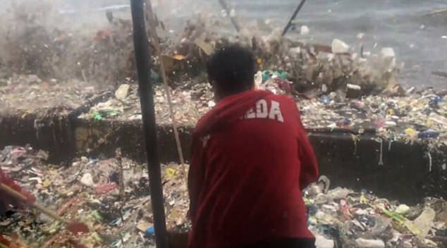 海浪裹挟垃圾袭击菲律宾海岸 环保人士冒险清理