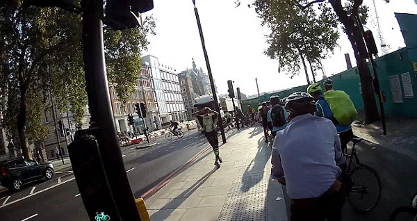 惊险一幕！伦敦街头一卡车企图闯红灯险些撞上骑车者
