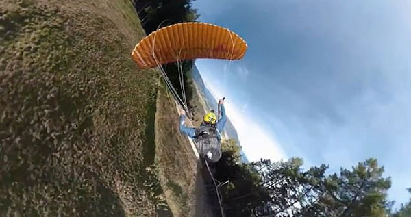 意男子背滑翔伞从山上超低空滑下 一览山区美景