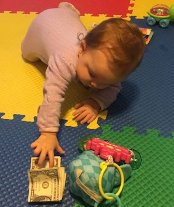 小财迷！美半岁大女婴不爱玩具爱钞票