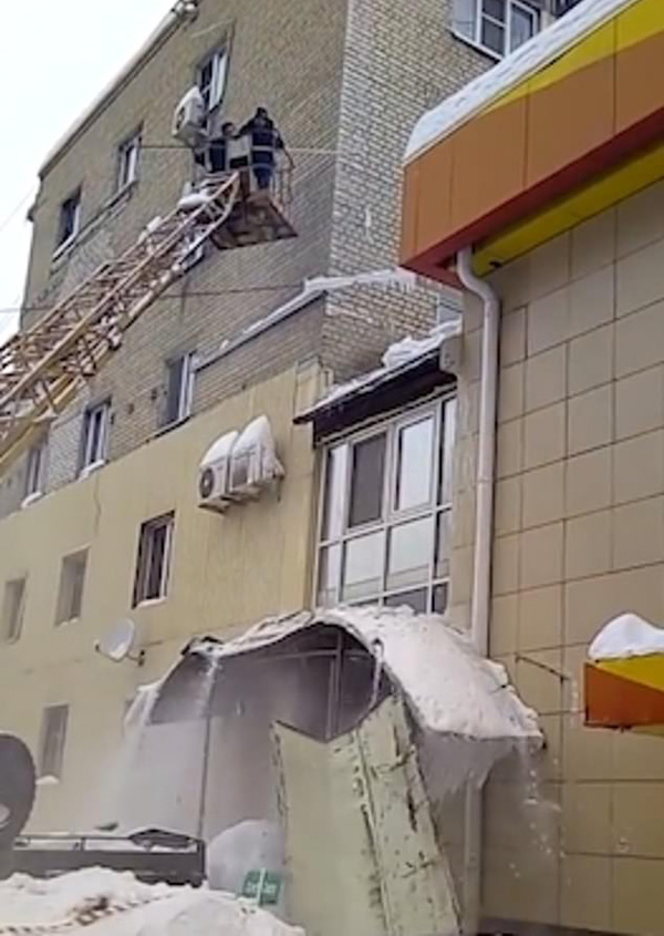 俄工人清理屋顶大冰柱 无意中砸坏下方门廊