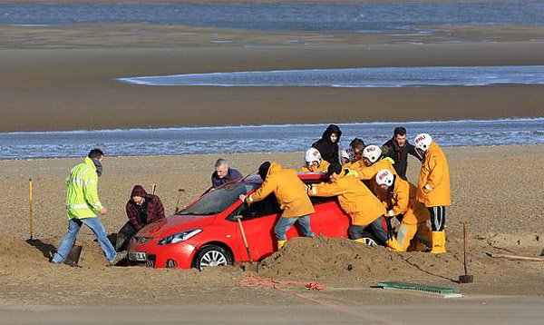 英海滩被困汽车获救援人员齐心协力解困
