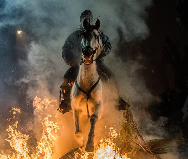 西班牙小镇居民骑马过火海庆祝节日 场景如世界末日