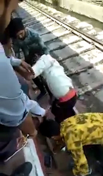 印一男子穿越铁轨突遇火车驶来 俯卧躲过一劫