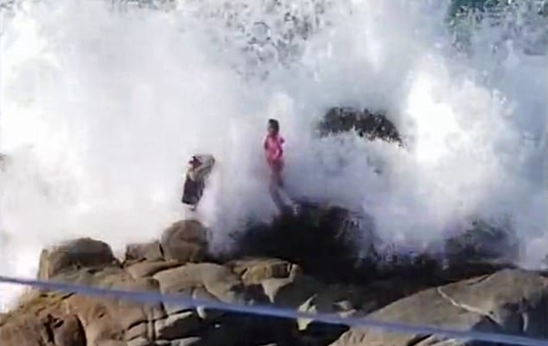 墨西哥男子海边礁石上为女友拍照被巨浪拍倒