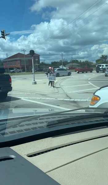 美国一少女手举标牌站路口中央受罚引群众争议