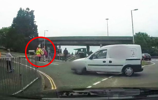 英交通安全员危险时刻挡在过路学生前保护其安全