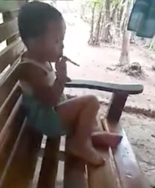 印尼一小男孩娴熟抽烟 身旁大人不以为然