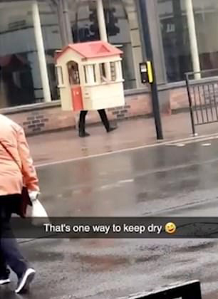 英国一男子突遇下雨 将玩具屋扛在头上避雨