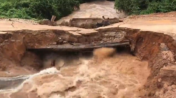 柬埔寨一处桥梁被洪水冲塌 两名骑车男子落水