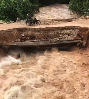 柬埔寨一处桥梁被洪水冲塌 两名骑车男子落水