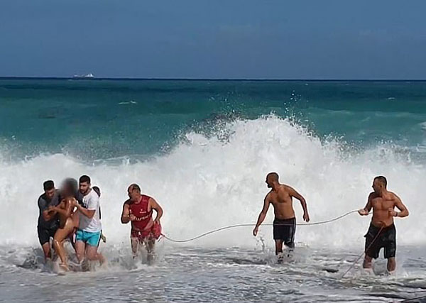 意大利男孩险被卷进汹涌海浪 救生员奋力将其救出