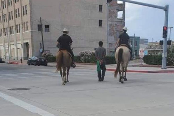美国俩警察骑马用绳子拴住黑人男子穿过街道 引发众怒