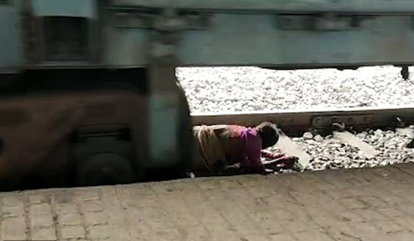 印度老妇人穿越铁轨遇险 急中生智逃过一劫